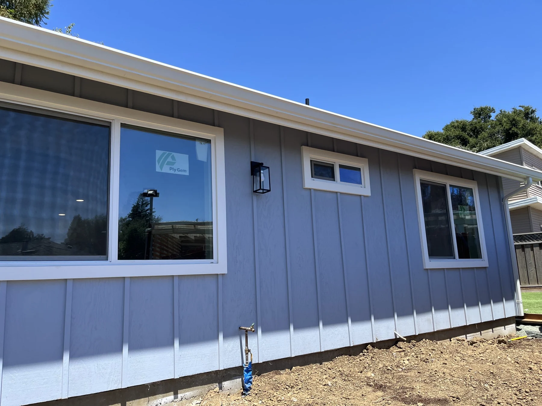 Blue-gray ADU exterior with white windows and board-and-batten siding.